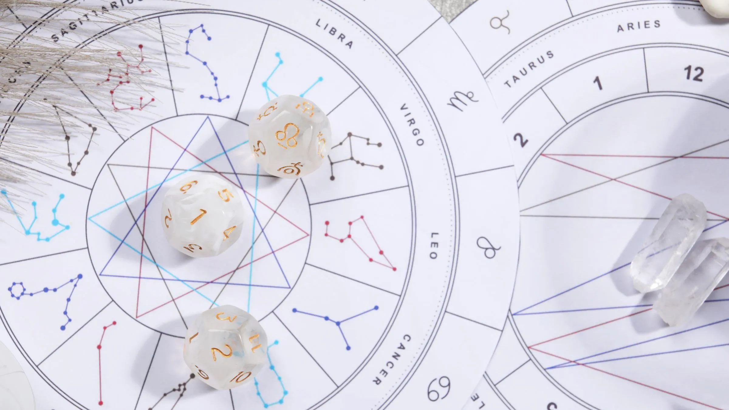 A printed zodiac birth chart with dice and clear quartz points.